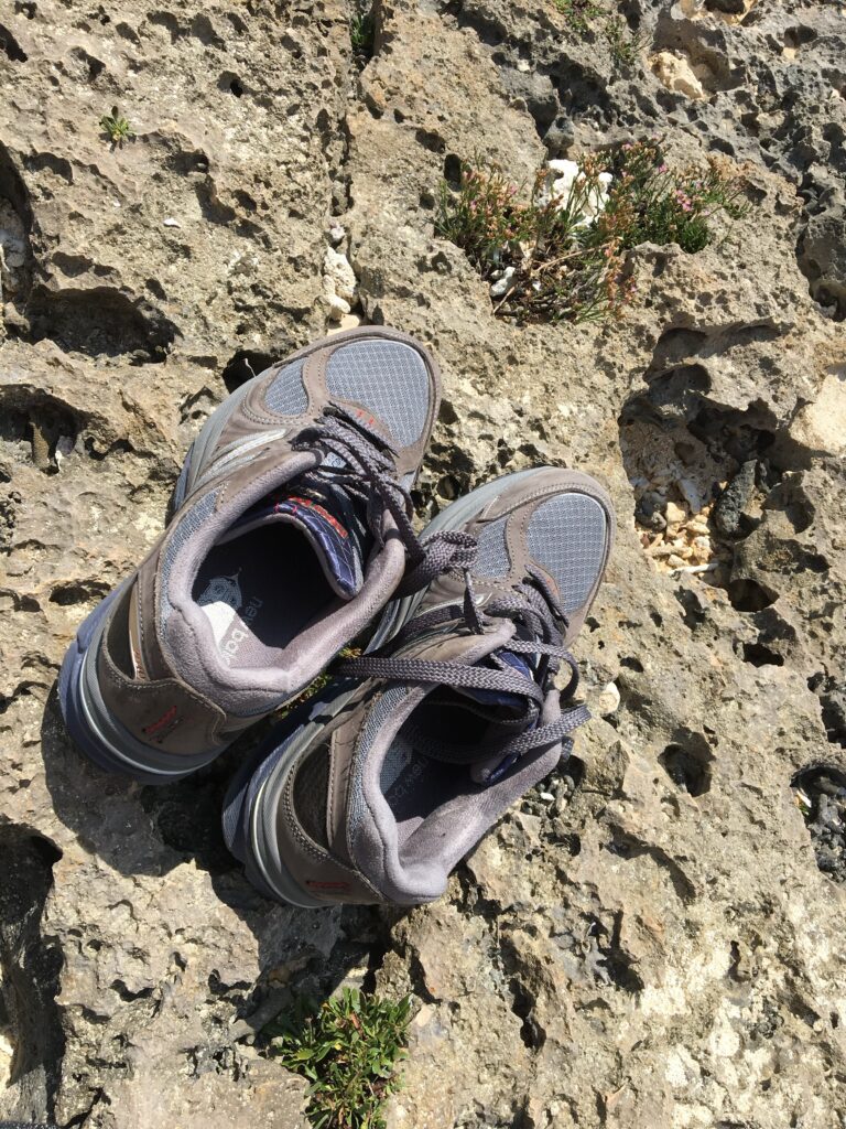 Rear view of New Balance M2040 V1 sneakers on a rocky beach in Okinawa, Japan
