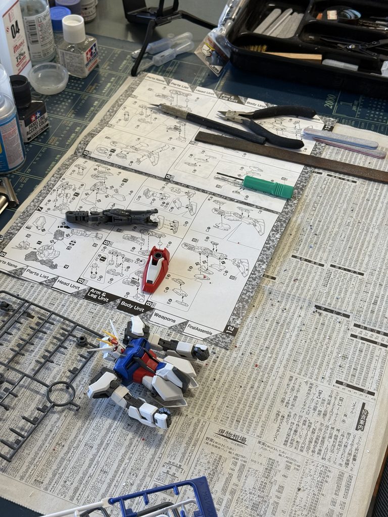 Work in progress Gunpla model with tools and parts on the desk